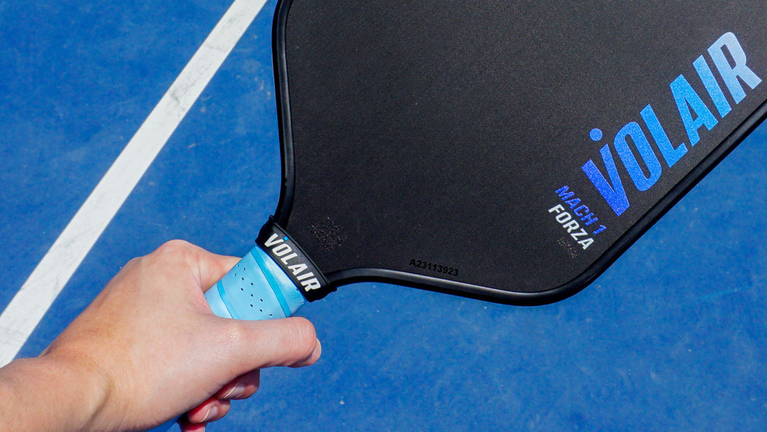 Diverse group of pickleball players energetically engaged in a match, gripping colorful paddles on a sunny outdoor court.